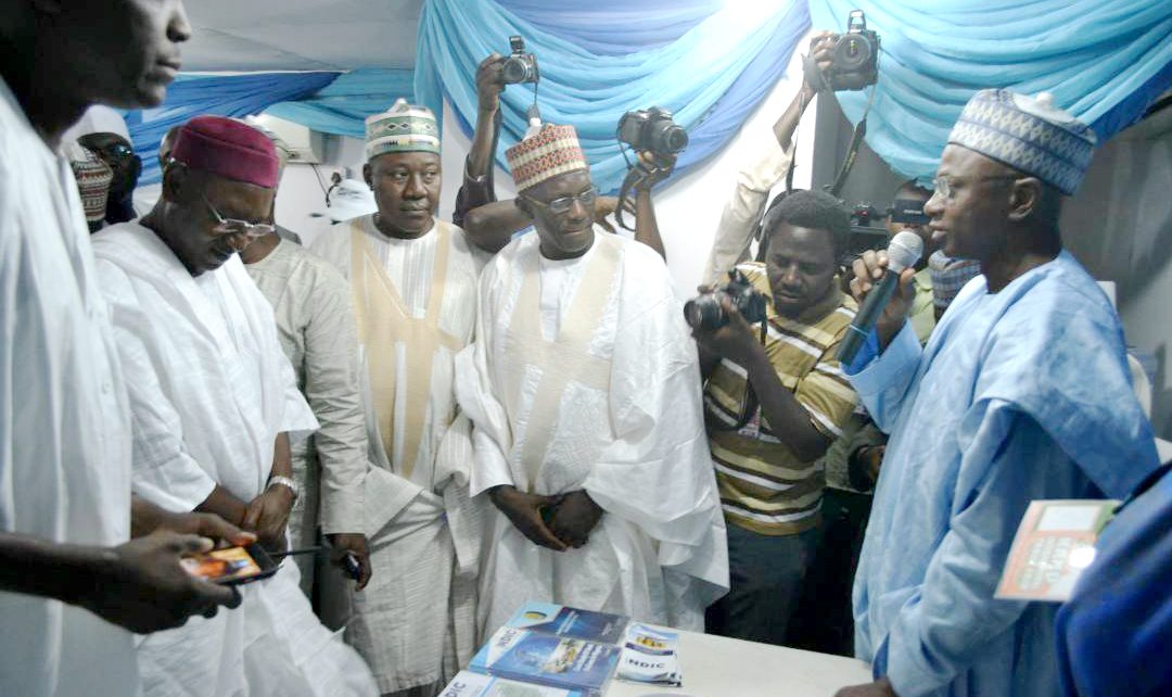 Kano State Deputy Governor, Prof. Hafiz Abubakar (2nd left) and his entourage listen as the Controller, NDIC Kano Zonal Office, Mr. Kabir Oniyangi (1st right) explains the mandate of the NDIC at the 2017 Kano International Trade Fair.